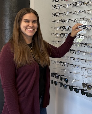 Photo of Maritza holding eyeglasses.